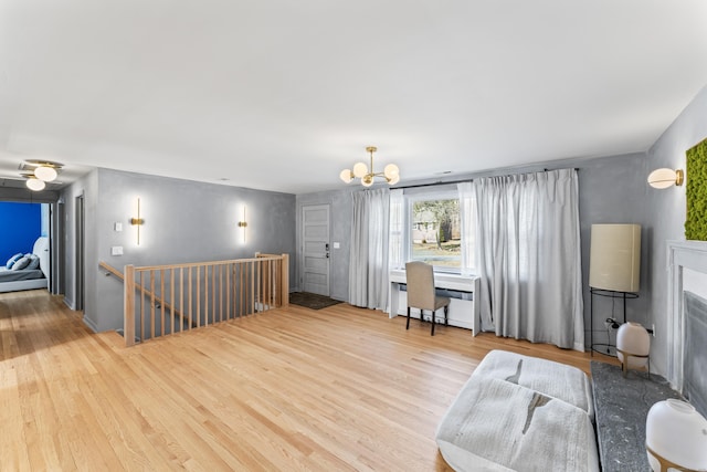 interior space featuring an upstairs landing, a chandelier, a fireplace, and wood finished floors