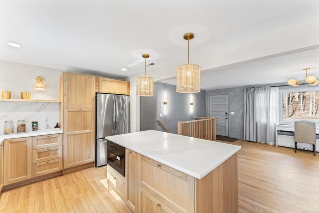 kitchen featuring light wood-type flooring, light brown cabinets, open shelves, stainless steel fridge, and light countertops