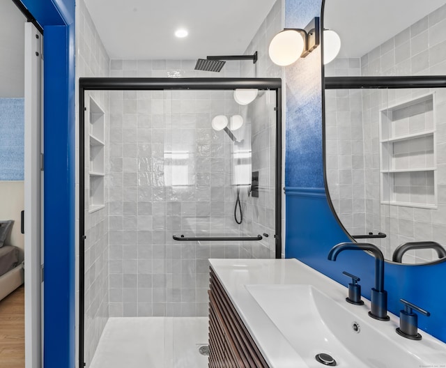 full bathroom featuring a stall shower, vanity, and wood finished floors