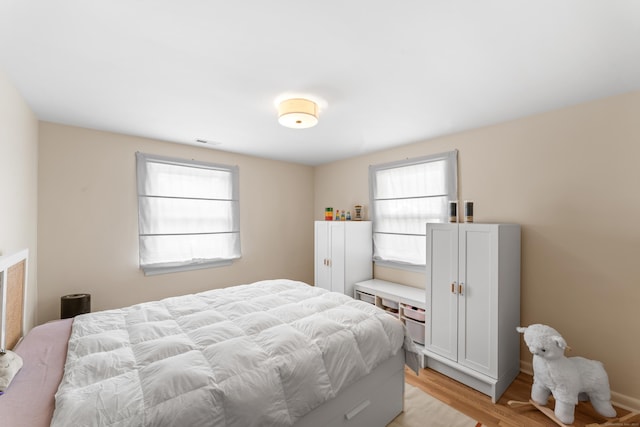 bedroom featuring light wood-style flooring and visible vents