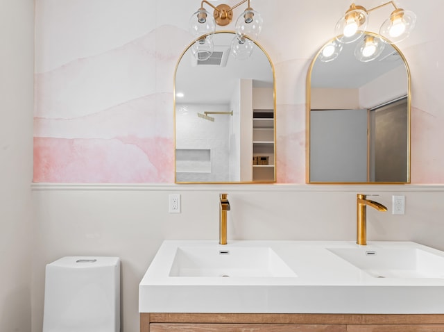 full bath with a sink, a shower, toilet, and double vanity