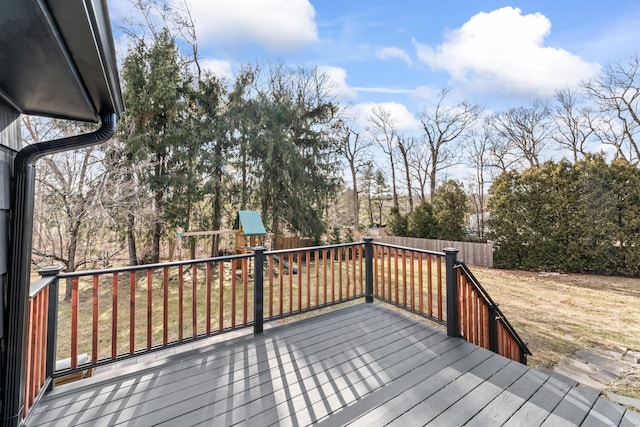 wooden deck featuring a playground and a fenced backyard