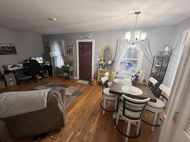 dining area with an inviting chandelier and wood finished floors