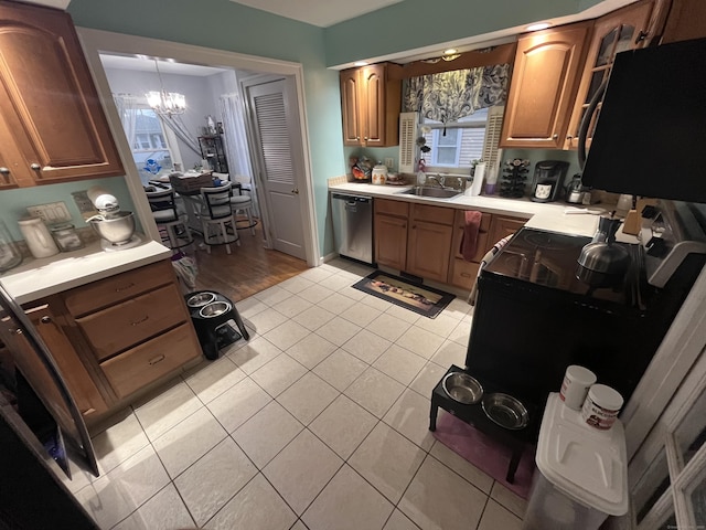 kitchen with an inviting chandelier, a sink, light countertops, black microwave, and dishwasher