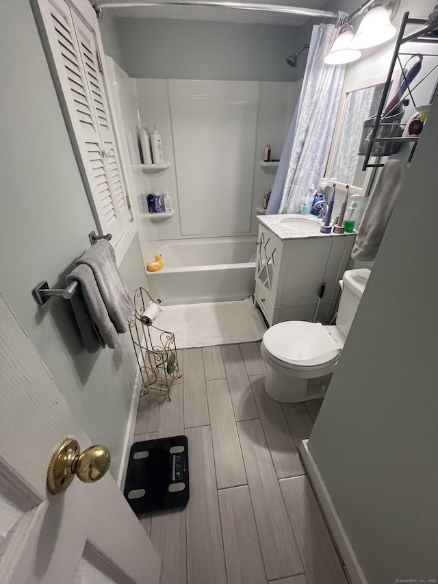 bathroom with shower / bath combination with curtain, toilet, vanity, and wood finish floors