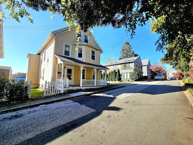 view of front of home with aphalt driveway and a porch