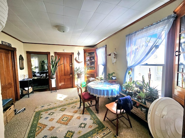 carpeted dining space featuring crown molding