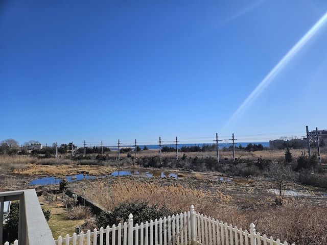 view of yard with a water view and fence