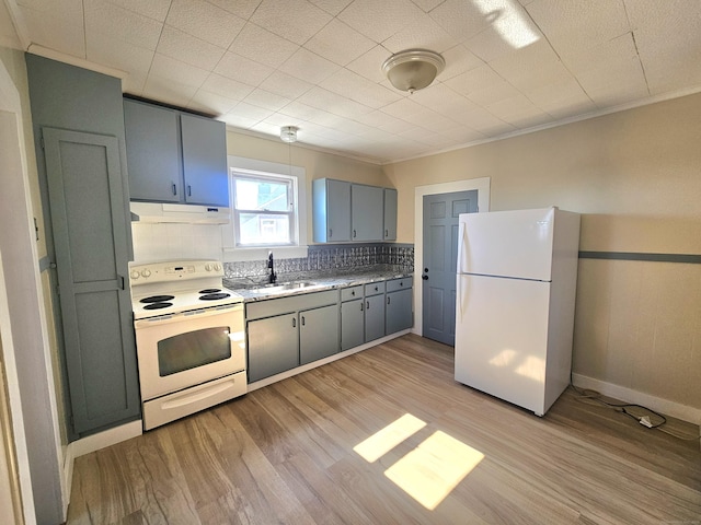 kitchen featuring white appliances, light wood finished floors, gray cabinetry, a sink, and under cabinet range hood