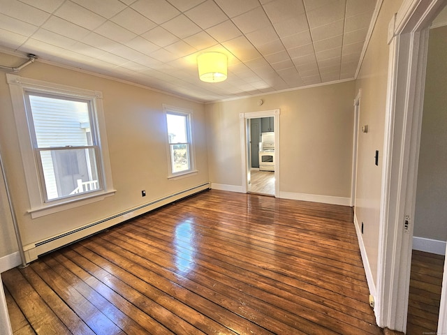 empty room featuring baseboard heating, ornamental molding, baseboards, and hardwood / wood-style floors