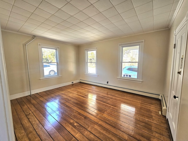 unfurnished bedroom featuring multiple windows, baseboard heating, crown molding, and hardwood / wood-style flooring