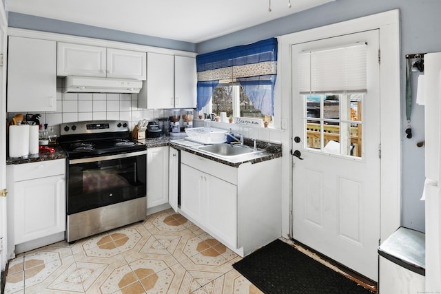 kitchen with under cabinet range hood, dark countertops, a sink, and electric stove