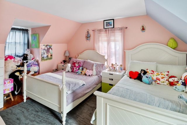 bedroom with vaulted ceiling and wood finished floors