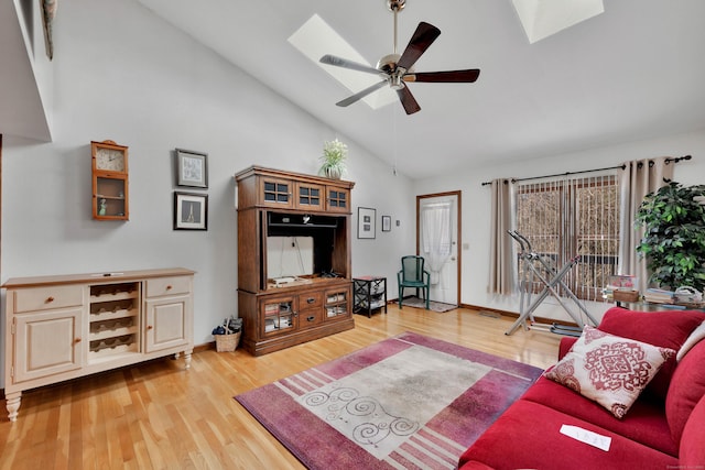 living room with high vaulted ceiling, a skylight, ceiling fan, and wood finished floors