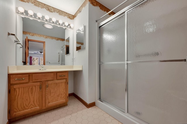 full bath with baseboards, vanity, and a shower stall