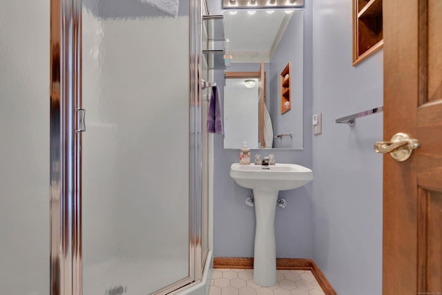 full bathroom featuring a shower stall and baseboards