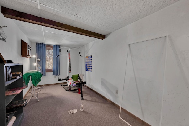 workout area featuring carpet flooring, baseboards, and a drop ceiling