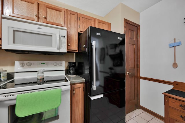 kitchen with light tile patterned floors, brown cabinets, and white appliances