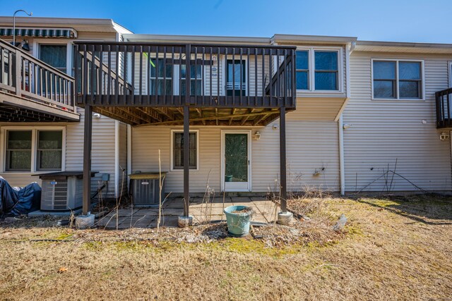 back of property featuring a deck, central AC unit, and a patio