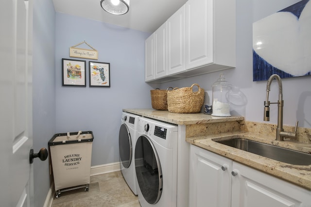 laundry room with a sink, cabinet space, baseboards, and separate washer and dryer