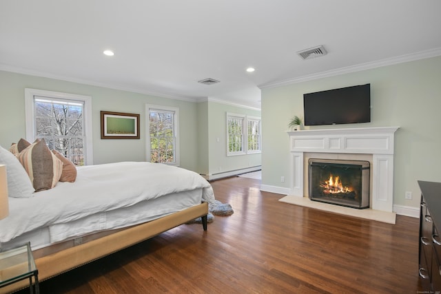 bedroom featuring visible vents, ornamental molding, wood finished floors, baseboards, and baseboard heating