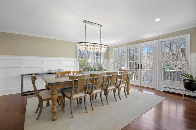 dining room featuring ornamental molding, dark wood-type flooring, french doors, wainscoting, and baseboard heating