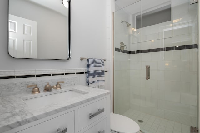 full bathroom with vanity, toilet, tile walls, and a shower stall