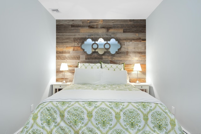 bedroom with visible vents and wooden walls