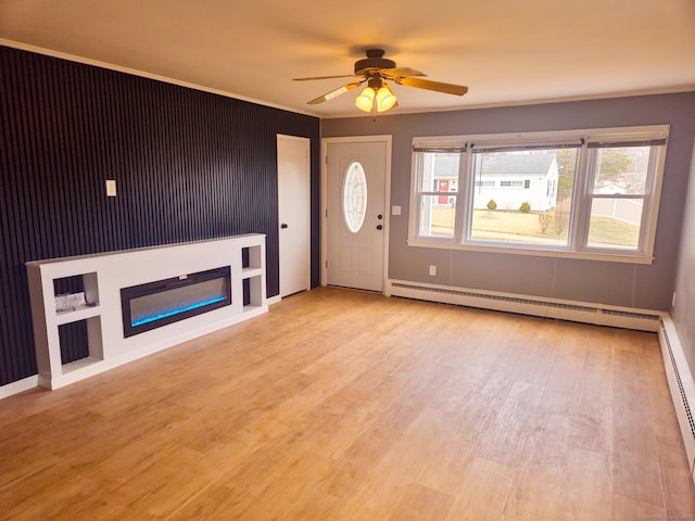 unfurnished living room with ornamental molding, a ceiling fan, a glass covered fireplace, light wood-style floors, and a baseboard radiator