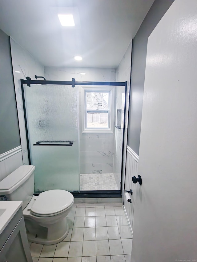 full bathroom with vanity, toilet, wainscoting, and a shower stall