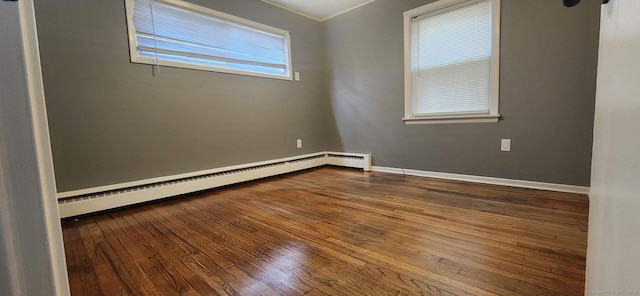 spare room featuring dark wood finished floors, baseboards, and baseboard heating