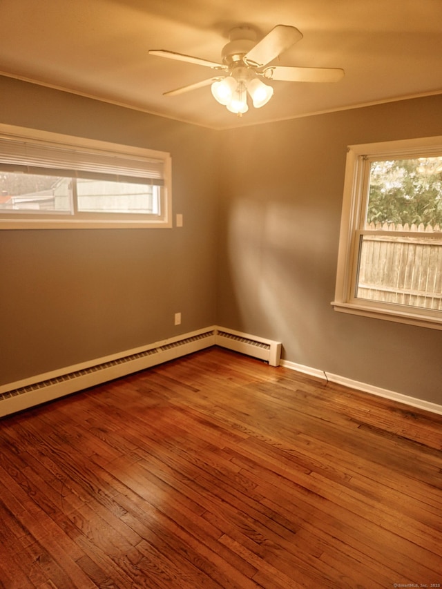 spare room featuring hardwood / wood-style floors, a ceiling fan, baseboards, and baseboard heating