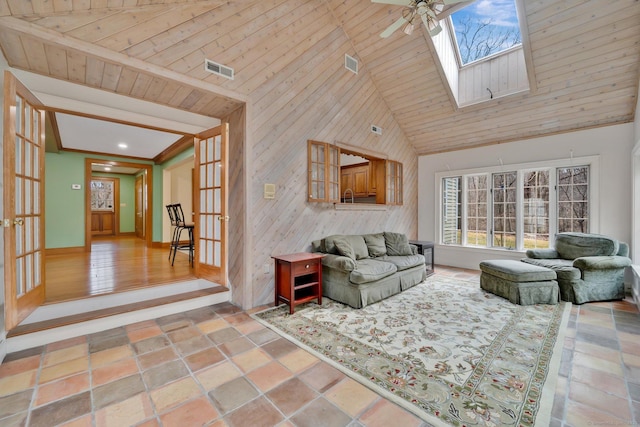 living room featuring visible vents, ceiling fan, french doors, a skylight, and high vaulted ceiling