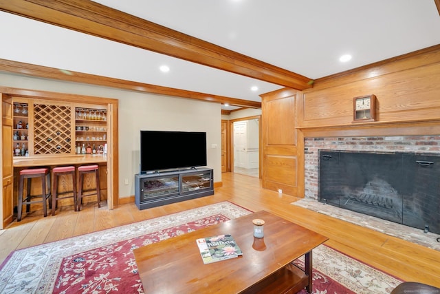 living room featuring hardwood / wood-style floors, beam ceiling, a brick fireplace, and recessed lighting