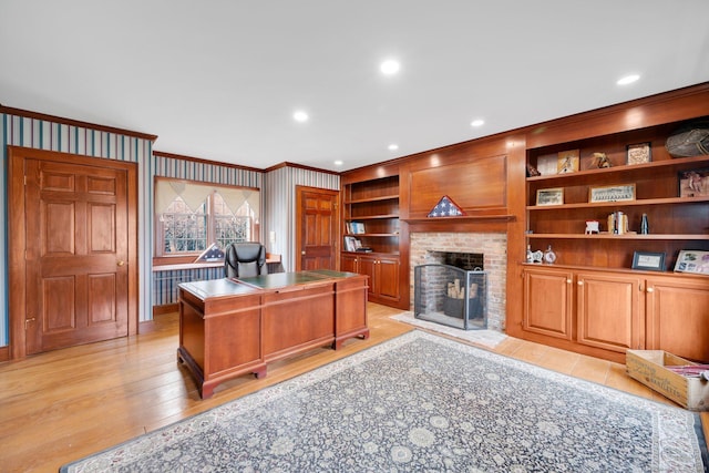 home office featuring light wood finished floors, ornamental molding, recessed lighting, wallpapered walls, and a brick fireplace