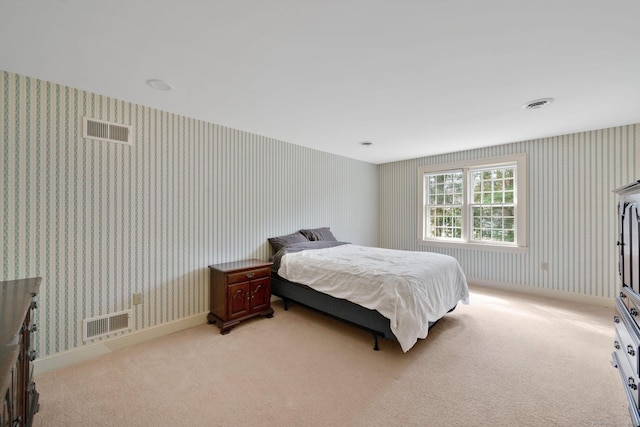 bedroom featuring wallpapered walls, visible vents, and light carpet