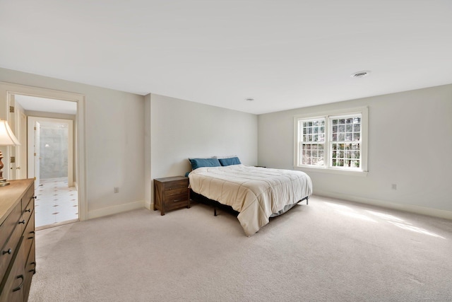 bedroom featuring baseboards, visible vents, and light carpet