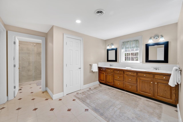 bathroom featuring a sink, visible vents, baseboards, and a tile shower