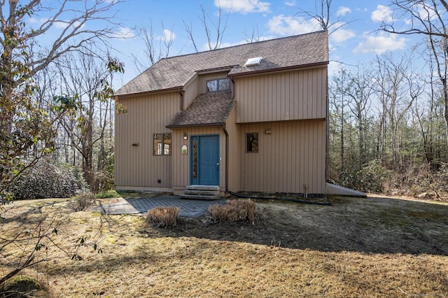 exterior space with a shingled roof and entry steps