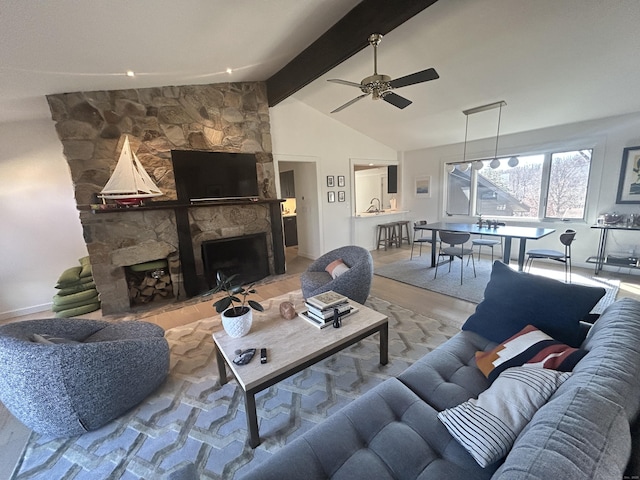 living area featuring a fireplace, lofted ceiling with beams, and ceiling fan