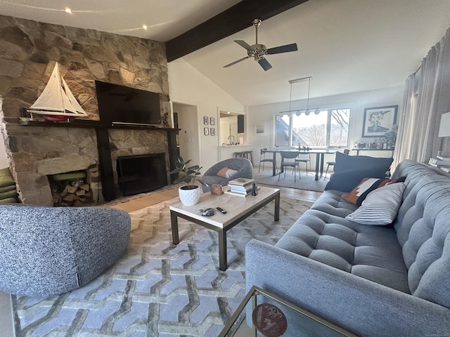 living room featuring a stone fireplace, vaulted ceiling with beams, a ceiling fan, and wood finished floors