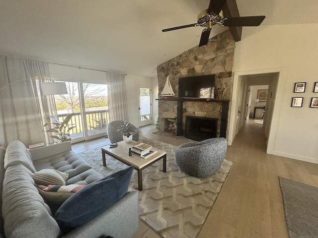 living room with wood finished floors, baseboards, high vaulted ceiling, a fireplace, and ceiling fan