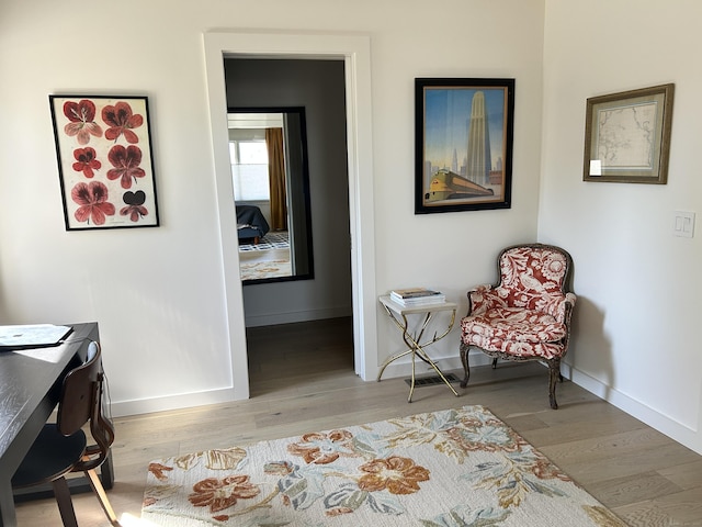 living area featuring baseboards and wood finished floors