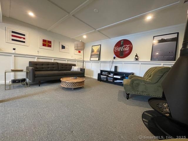 carpeted living area featuring a decorative wall