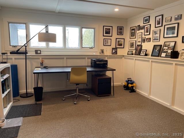 home office featuring a wealth of natural light, carpet, and a decorative wall