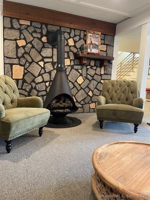 living area with carpet flooring and a wood stove