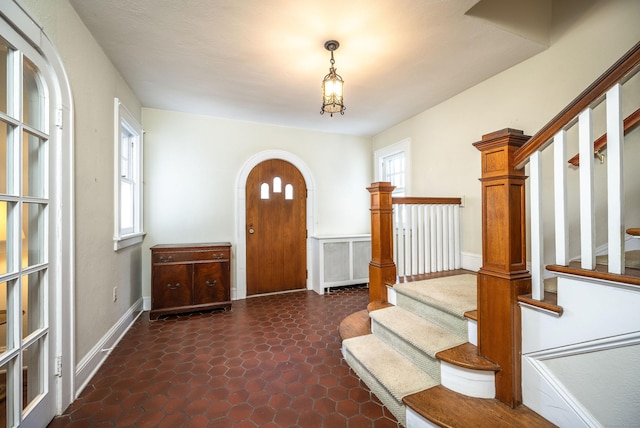 foyer featuring stairway and arched walkways