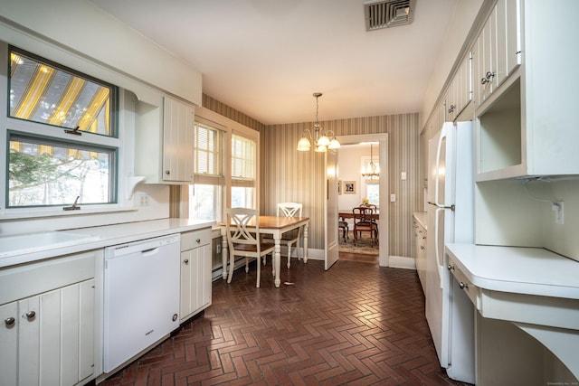 kitchen with visible vents, light countertops, an inviting chandelier, brick floor, and white appliances