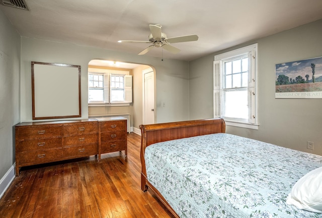 bedroom with visible vents, multiple windows, dark wood-type flooring, and baseboards