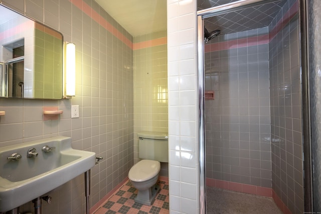 full bath with tile walls, toilet, a shower stall, and a sink